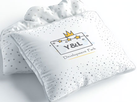 Soft children's pillow with branding by Y&L Development Park, featuring a star and crown logo for a playful design.
